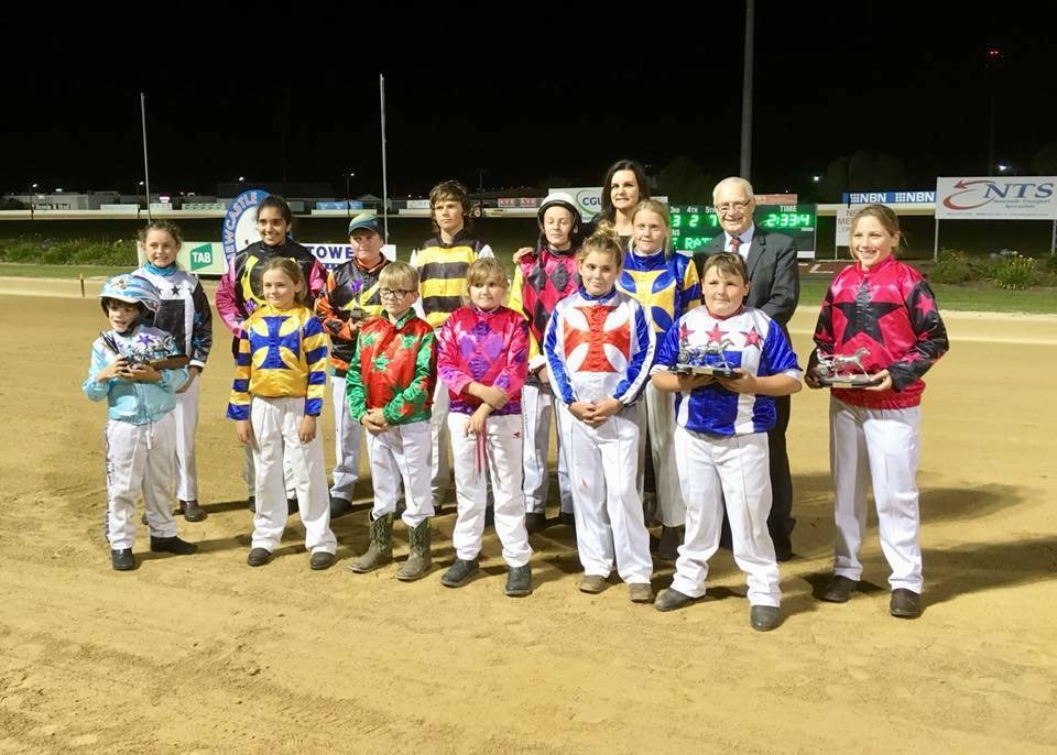 Club drivers in their racing silks lined up on the track at Newcastle Paceway after a race night